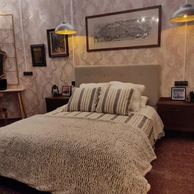 a bedroom with a bed with a blanket and pillows at Barcelona RAVAL Y ROQUETES in Hospitalet de Llobregat