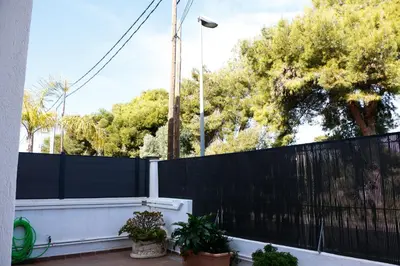 a black fence with potted plants on a patio at Cozy Apartment Rocamar in Sant Pere de Ribes