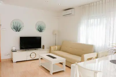 a living room with a couch and a flat screen tv at Cozy Apartment Rocamar in Sant Pere de Ribes
