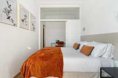a bedroom with a bed with an orange blanket on it at Sants Station Base 500Mb Wi-Fi AC in Barcelona