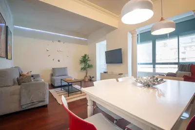 a living room with a table and chairs and a living room at Apartamento de 3 habitaciones en Sant Antoni in Barcelona