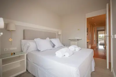 a bedroom with a white bed with towels on it at Ático dúplex con cinco dormitorios in Barcelona