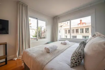 a bedroom with a large window with towels on a bed at Ático dúplex con cinco dormitorios in Barcelona