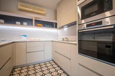 a kitchen with white cabinets and a stove top oven at Ático dúplex con cinco dormitorios in Barcelona