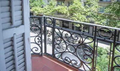 an iron railing on a balcony with a sidewalk at Apartamento de cuatro dormitorios en Calle Aribau You Stylish Apartments in Barcelona