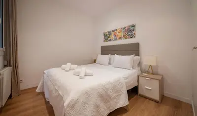 a bedroom with a bed with two towels on it at Apartamento de cuatro dormitorios en Calle Aribau You Stylish Apartments in Barcelona