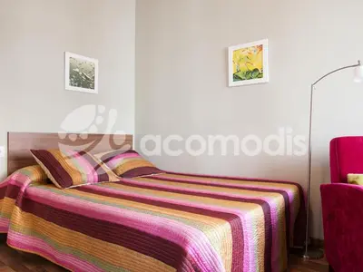 a bedroom with a bed with a striped blanket at El Born Apartment - Santa Caterina Market - Walk to Cathedral & Picasso Museum in Barcelona