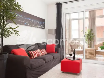 a living room with a gray couch and red pillows at Ideal Location in L'Eixample! - Walk to Sagrada Familia and Barcelona Old Town! in Barcelona