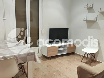 a living room with a tv and a table and chairs at Passatge Concepcio in Hospitalet de Llobregat