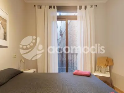 a bedroom with a bed and a large window at Vigatans in Barcelona