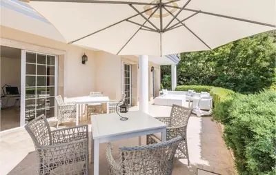 a patio with a white table and chairs and an umbrella at 5 Bedroom Amazing Home In Cabrils in Cabrils