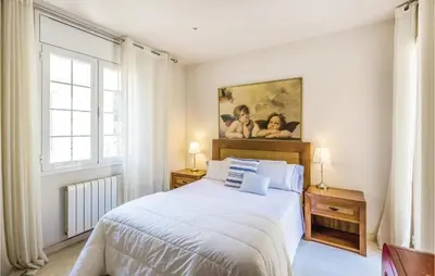 a bedroom with a bed and a painting on the wall at 5 Bedroom Amazing Home In Cabrils in Cabrils