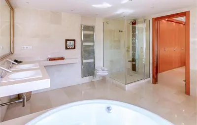 a bathroom with a tub and a shower and a sink at 5 Bedroom Amazing Home In Cabrils in Cabrils