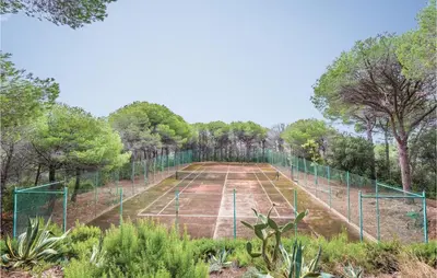 an empty tennis court with trees on it at Nice Home In Arenys De Munt in Arenys de Munt