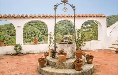 a patio with a fountain and potted plants at Nice Home In Arenys De Munt in Arenys de Munt