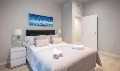 a white bedroom with a large bed with towels on it at Apartamento 4 dormitorios en Calle Roselló You Stylish Apartments in Barcelona