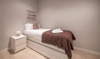 a small bedroom with a bed and a night stand at Apartamento 4 dormitorios en Calle Roselló You Stylish Apartments in Barcelona