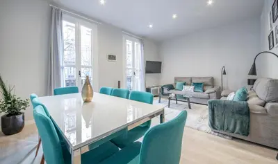 a living room with a table and blue chairs at Apartamento 4 dormitorios en Calle Roselló You Stylish Apartments in Barcelona