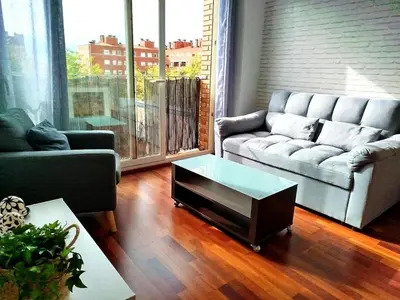 a couch in a living room with a large window at La Tranquilidad en Sabadell in Sabadell