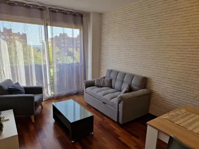 a dining room table with chairs and a couch at La Tranquilidad en Sabadell in Sabadell
