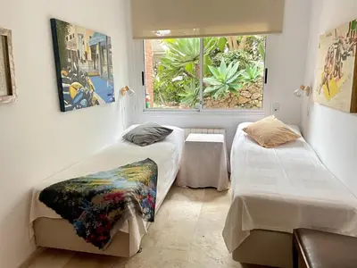 a dining room with a wooden table and white chairs at Entire villa with pool, ocean & mountain views in Sitges