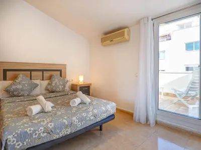 a bedroom with a bed with white pillows and a window at Ribes Duplex by Hello Homes Sitges in Sitges