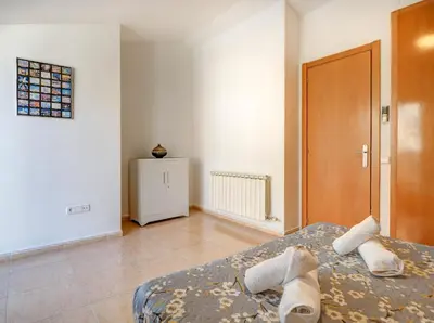 a bedroom with a bed and a wooden door at Ribes Duplex by Hello Homes Sitges in Sitges