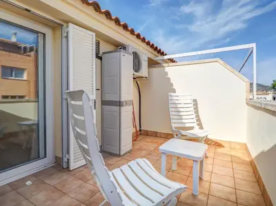 a patio with two chairs and a refrigerator on a balcony at Ribes Duplex by Hello Homes Sitges in Sitges