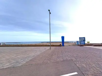 a street light on a brick sidewalk next to the beach at CUNIT PLaYA in Cunit