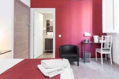 a bedroom with red walls and a chair and a bed at BruStar Sagrada Familia in Barcelona