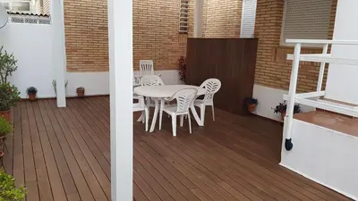 a patio with a table and chairs on a deck at Sitges Oasi in Sitges