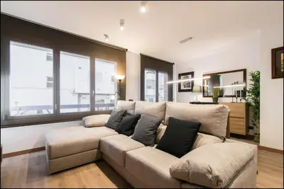 a living room with a large couch and windows at Sitges Oasi in Sitges