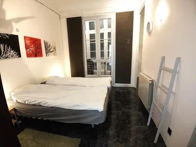 two beds in a small room with a window at Spacious aptmt close to Pl Universidad and Pl Catalunya, 2,5 bedrooms, balcony, heating, elevator Min 31 nights in Barcelona