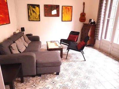 a living room with a couch and chairs and a guitar at Spacious aptmt close to Pl Universidad and Pl Catalunya, 2,5 bedrooms, balcony, heating, elevator Min 31 nights in Barcelona