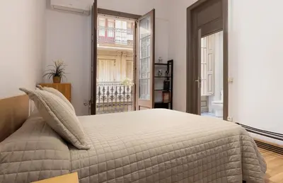 a bedroom with a bed and a large window at ApartEasy - PURE GRACIA, excellent location in Barcelona