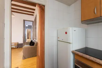 a kitchen with a refrigerator and a living room at ApartEasy - PURE GRACIA, excellent location in Barcelona