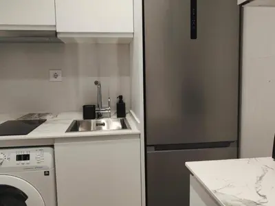 a kitchen with a sink and a washing machine at Gran Vía de Carlos III B in Barcelona