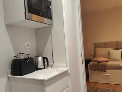 a kitchen with a microwave and a coffee maker on a shelf at Gran Vía de Carlos III B in Barcelona