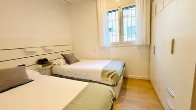 two beds in a small room with a window at Apartamento familiar by prestigi in Terrassa
