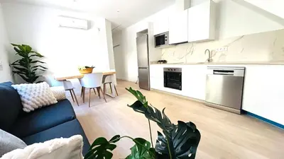 a kitchen and living room with a couch and a table at Apartamento familiar by prestigi in Terrassa
