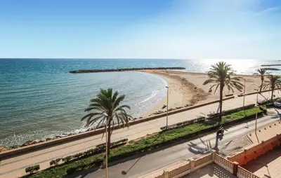 a beach with palm trees and the ocean at Cozy Home In Calafell With Wifi in Calafell