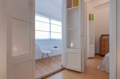 a room with a door and a chair and a table at Playa a pie y a 15 minutos de Ramblas y Plaza Catalunya en metro in Sant Adria de Besos