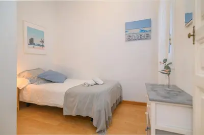 a small bedroom with a bed and a table at Playa a pie y a 15 minutos de Ramblas y Plaza Catalunya en metro in Sant Adria de Besos