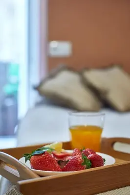 a plate of strawberries on a tray with a glass of orange juice at BBarcelona Mallorca Flats in Barcelona