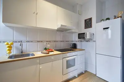 a white kitchen with a sink and a refrigerator at BBarcelona Mallorca Flats in Barcelona