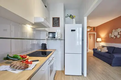 a kitchen with a refrigerator and a table with vegetables at BBarcelona Mallorca Flats in Barcelona
