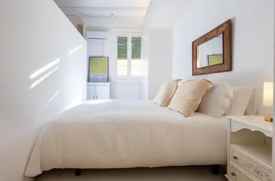 a bedroom with a white bed with a mirror at Stay U-nique Apartments Llibertat in Barcelona