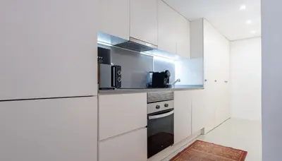 a kitchen with white cabinets and a stove at Stay U-nique Apartments Llibertat in Barcelona