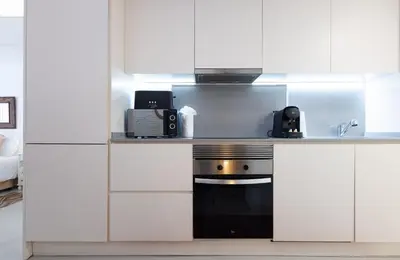 a kitchen with white cabinets and a stove at Stay U-nique Apartments Llibertat in Barcelona