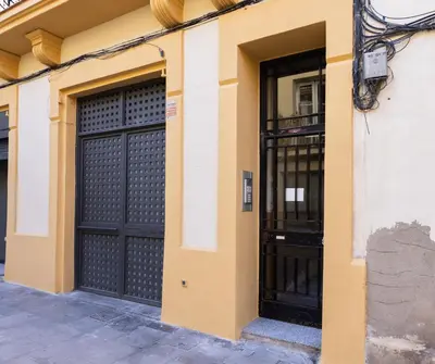a pair of black doors on a yellow building at Stay U-nique Apartments Llibertat in Barcelona